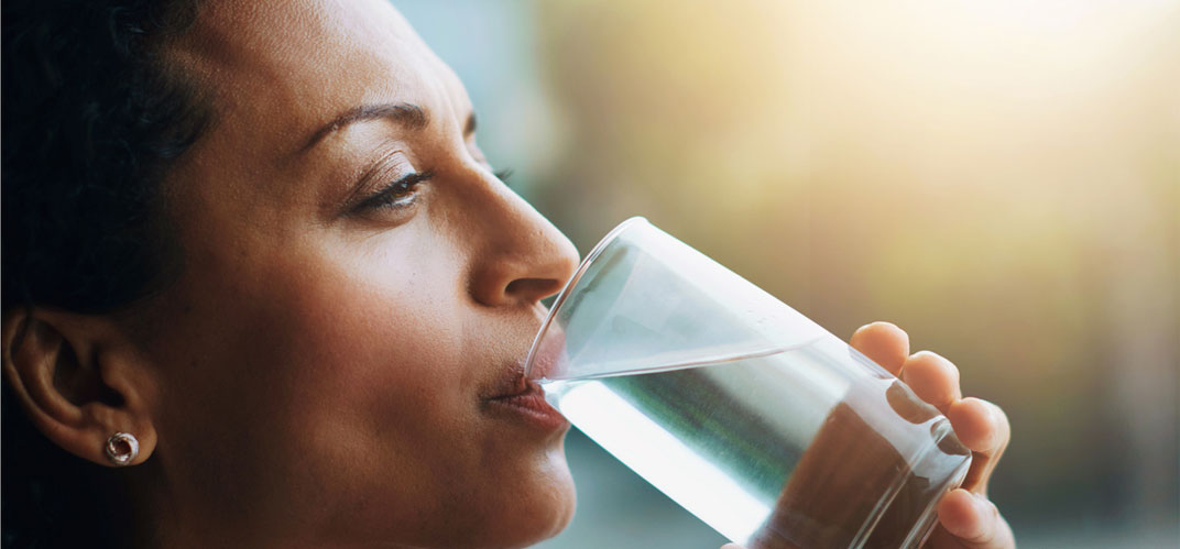 Ressource en eau : une femme buvant un verre d'eau